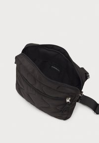 Borsa a tracolla nera trapuntata con chiusura zip, tracolla regolabile e fodera interna liscia. Dotata di accessori in tonalità argento e etichetta con il marchio.