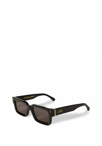 Zwarte rechthoekige zonnebril met donkere lenzen, met gouden accenten op het frame en de armen. Tekst op de arm leest "DE INFAME GURU."