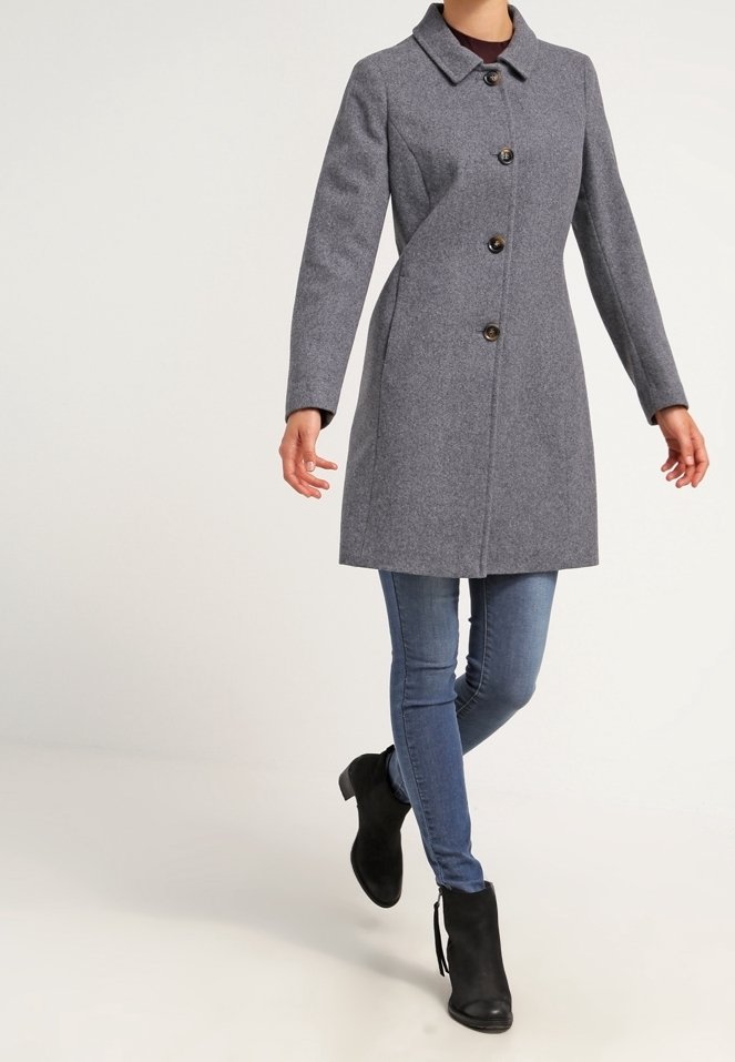Grå ullblandad kappa med krage, enkelknäppt stängning och två framfickor. Bärs över blå jeans och svarta ankelstövlar.