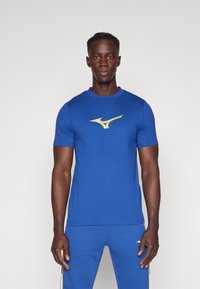 Zila sporta t-kreklu ar īsām piedurknēm, priekšpusē ar zelta logotipu. Izgatavots no gludas auduma ar apaļu kakla dizainu.
