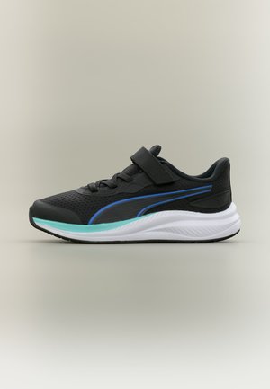 Baskets de sport noires avec lacets et sangle Velcro, bande bleue et semelle blanche épaisse, présentées de profil sur un fond neutre.