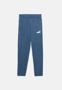 Blå Puma-träningsbyxor med elastiskt midjeband och sidofickor, försedda med vitt Puma-logotyp på vänster lår.