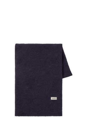 Mörk marinblå, texturerad filt med en mjuk känsla. Fälld, med en liten rektangulär tagg som har "THINKING MU"-loggan på en kant.