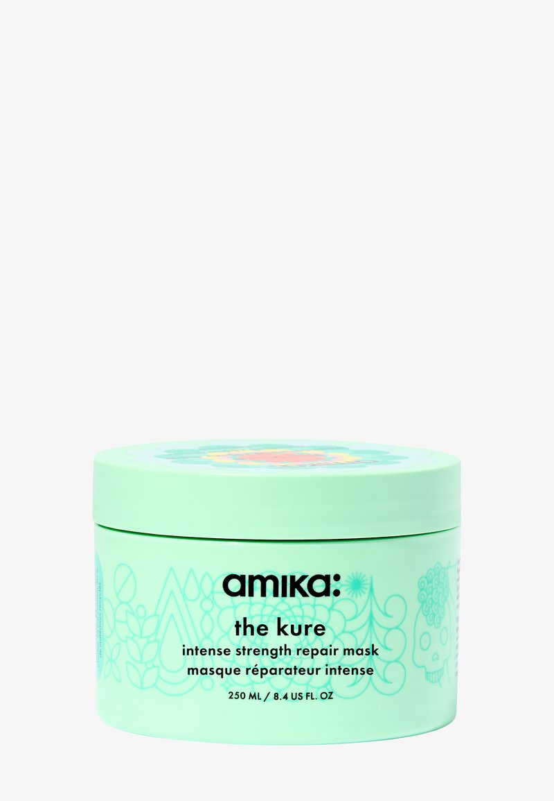 Récipient rond vert avec un motif floral et un texte noir. L'étiquette indique « amika : le masque réparateur intensif Kure », volume de 250 mL.