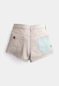 Lichtbeige shorts met een rafelrand, voorzien van twee achterzakken; één met een mintgroene flap en stiksel detail. Bruin merketiket bevestigd.