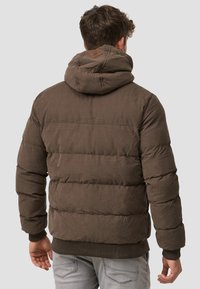 Brun polstret jakke med hætte, der har en struktureret finish, ribbede manchetter og en læderlogo detalje på ryggen.