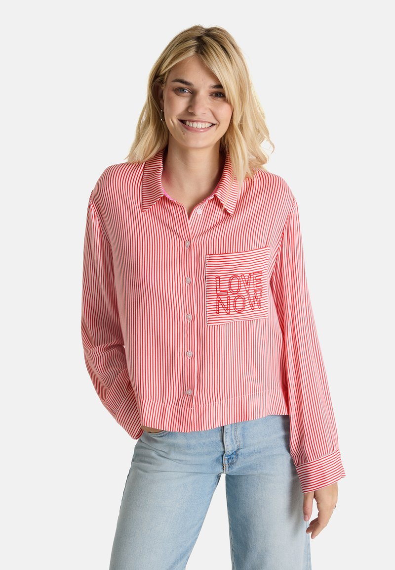 Red and white striped button-up shirt with long sleeves, featuring a pocket embroidered with "LOVE NOW" in red thread.