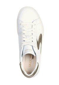 Zapatilla de piel blanca con puntera redonda, cordones planos y un acento dorado en el lateral. Plantilla texturizada con el logotipo de la marca en su interior.