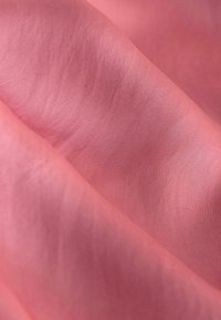 Tessuto leggero e texturizzato in una morbida tonalità di rosa, con sottili variazioni di tonalità e una trama fine e liscia.