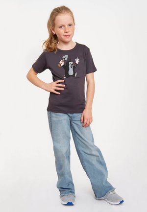 Gray short-sleeve t-shirt featuring a cartoon mole holding a tool; paired with light blue loose-fitting jeans and gray sneakers.