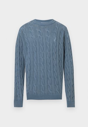 Blauer Strickpullover mit Zopfmuster, langen Ärmeln sowie gerippten Bündchen und Saum. Der Stoff hat eine strukturierte Optik.