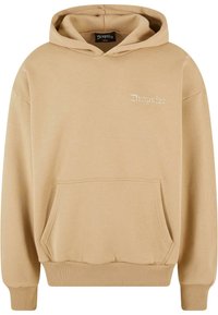 Beige hoodie with a front pocket, ribbed cuffs, and waistband. Features a small embroidered logo on the chest. Made from soft fabric.