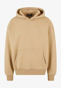 Sudadera beige con un bolsillo frontal, puños y cintura acanalados. Presenta un pequeño logo bordado en el pecho. Fabricada en tejido suave.