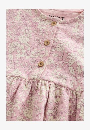 Vestito floreale rosa con abbottonatura davanti con tre bottoni in legno, gonna arricciata e tessuto di cotone strutturato con motivi floreali bianchi.