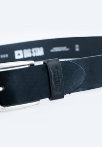 Cinturón de cuero negro con una hebilla de metal plateado y un lazo de cuero negro con la marca. Textura suave con un diseño minimalista y sin patrones.