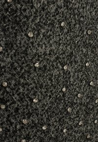 Tessuto testurizzato nero e grigio con un motivo sottile, impreziosito da strass trasparenti sparsi per un tocco di dettaglio.