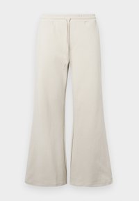 Pantalones de pierna ancha color beige claro, fabricados con una tela suave, que cuentan con una cintura elástica con cordón y bolsillos laterales.