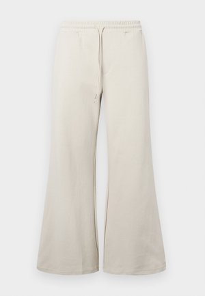 Lys beige vide ben bukser lavet af blødt stof, der har et elastisk taljebånd med snor og sidelommer.