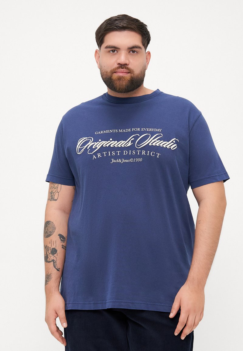 Navy blue cotton t-shirt with short sleeves, crew neckline, and white text graphic reading "Original Studio Artist District."