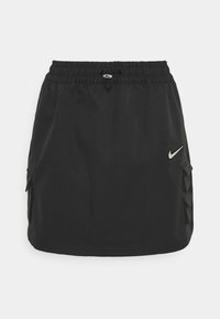 Czarna spódnica sportowa z elastycznym pasem i sznurkiem. Posiada małe logo Nike oraz boczne kieszenie z plecionym wykończeniem.