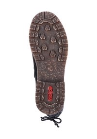 Zapatilla negra con una suela de goma texturizada que presenta un patrón hexagonal y el logotipo rojo de "Rieker". Talla marcada como 37 en la suela.