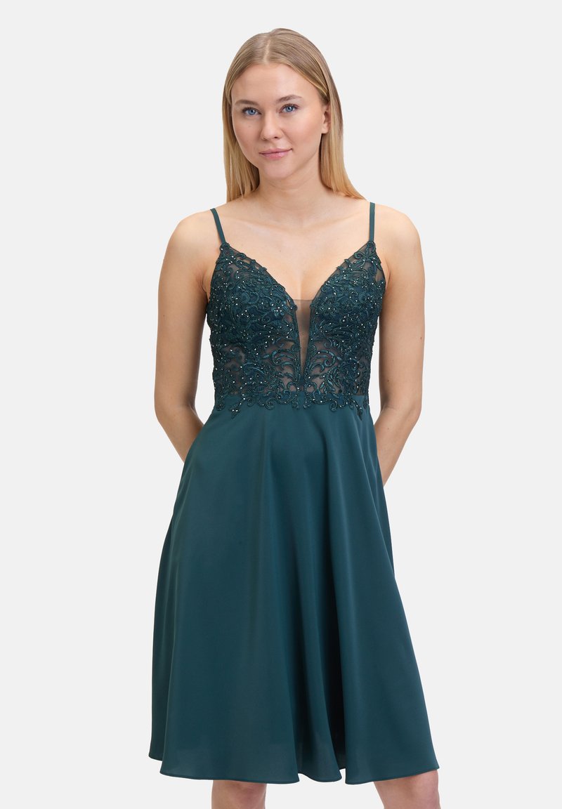 Turkusowa sukienka z głębokim dekoltem w kształcie litery V, ozdobiona bodice z misternym haftem koralikowym oraz zwiewną spódnicą. Regulowane ramiączka spaghetti.