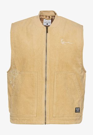 Beige kordbársonyos mellény zipzárral elöl, bomber stílusú nyakkal, két elülső zsebbel és hímzett logóval a bal oldalon.