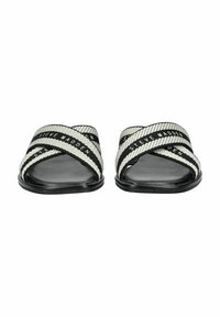 Sandales slide noir et blanc avec des brides en tissu croisées. Logo "Steve Madden" visible sur les brides. Semelle plate avec une surface lisse.