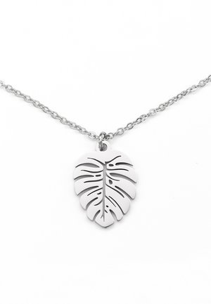 Collier chaîne en argent avec un pendentif en argent poli en forme de feuille de Monstera stylisée avec des découpes.