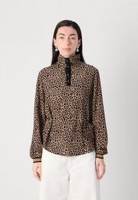 Blouse met luipaardenprint en hoge kraag, zwarte knopenrij, elastische mouwen en trekkoord in de taille. De stof lijkt zacht en textuur te hebben.