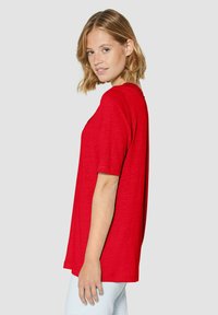 Rode T-shirt met korte mouwen, losse pasvorm, ronde halslijn, lichtgewicht stof, gladde textuur, met een eenvoudig ontwerp zonder verdere patronen.