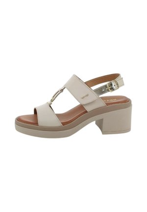 Beige open-toe sandaal met blokhak, verstelbare enkelriem met gesp en decoratief metalen detail op het voorste bandje.