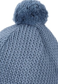 Blue knitted beanie with a textured pattern, featuring a soft pom-pom on top. Constructed from warm fabric, ideal for cold weather.