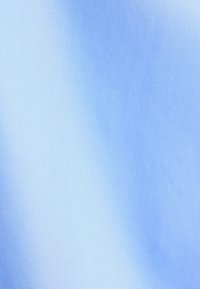 Lichtblauwe stof met een gladde textuur en subtiele glans, die een gradient-effect toont met tinten die overgaan van donkerder naar lichter blauw.