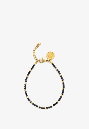 Bracelet à perles noires avec des accents en métal doré, une fermeture à pince homard avec une chaîne d'extension et un pendentif logo.