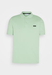 Polo vert clair à manches courtes avec deux boutons et un petit logo noir Calvin Klein sur le côté gauche de la poitrine.