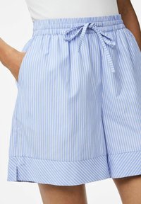 Zilas un balts svītrots bikses ar elastīgu jostasvītru un auklu, ar kabatām un pleitu apakšmalu. Izgatavoti no viegla auduma.