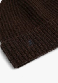 Brown ribbed knit beanie made from soft wool, featuring a folded cuff and a small embroidered skull logo on the side.