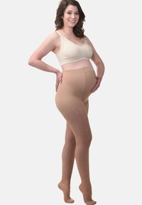 Collant maternità beige con una texture liscia e elastica, progettati per supportare e adattarsi a una pancia in crescita. Gambe traslucide con finitura opaca.