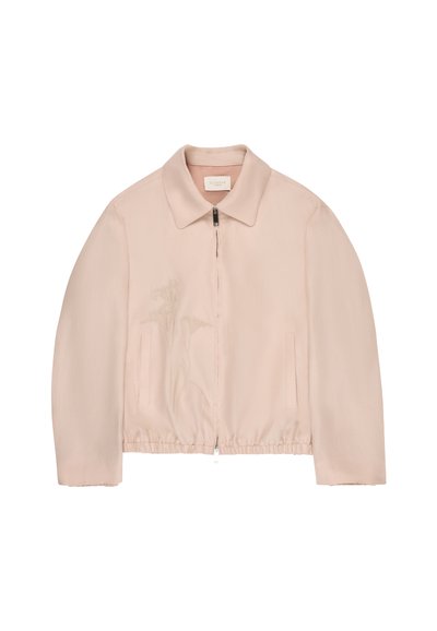 Beige zip-up jacket with collar, elastic hem, subtle floral embroidery on the left side, and two front vertical pockets.