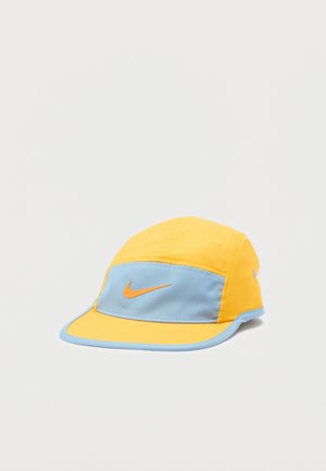 Nike pet met een geel-blauw kleurenpalet, gemaakt van lichtgewicht stof met een gebogen klep en een oranje logodetail aan de voorkant.