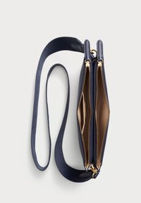 Ναυτικό χιαστί τσάντα με δύο φερμουάρ, χρυσές λεπτομέρειες και υφασμάτινη λωρίδα. Ο εσωτερικός χώρος διαθέτει απαλό, ανοιχτό καφέ φόδρα.