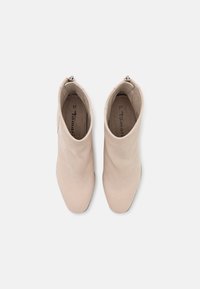 Botas de tobillo beige de cuero suave, con punta afilada y cierre de cremallera. Talla 37, que presenta un diseño elegante y minimalista.