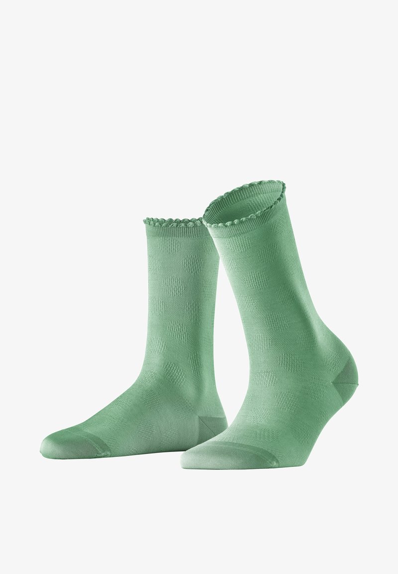 Chaussettes chevilles vertes avec un motif texturé de points légèrement surélevés, des bords festonnés sur le dessus et un talon et un orteil renforcés pour plus de durabilité.