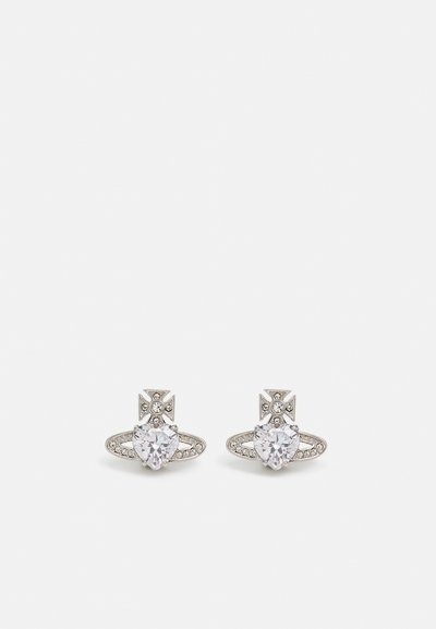 Orecchini in tono argento con cristalli a forma di cuore, dotati di un design dettagliato e piccole pietre decorative che circondano il gemma centrale.