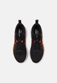 Black athletic shoes with orange accents, featuring a breathable mesh upper, padded collar, and flexible rubber outsole.