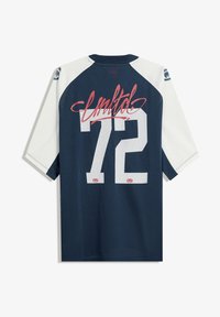 Maglia in rete blu navy con maniche bianche, caratterizzata dalla scritta "United" in corsivo rosa e dal numero "72" in lettere bianche a blocco. Texture morbida, design sportivo.