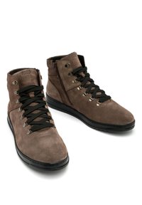 Brązowe zamszowe botki za kostkę z czarnymi sznurówkami i metalowymi oczkami. Zamek błyskawiczny z boku i czarna gumowa podeszwa. Gładka faktura i nowoczesny design.