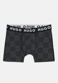 Juodos bokso šortai su toniniu "HUGO" logotipo raštu, su kontrastingu juodu ir baltu elastingu juosmeniu. Minkšta, elastinga medžiaga.