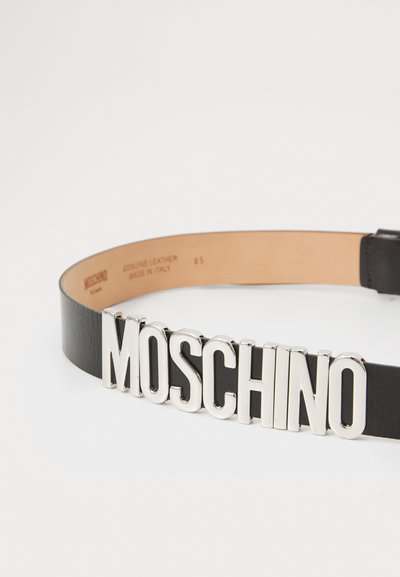 Musta nahkavöö, millel on hõbedane "MOSCHINO" logo, mis on esiplaanil selgelt nähtav. Siseosa on tan, märgitud "Genuine Leather, Made in Italy."